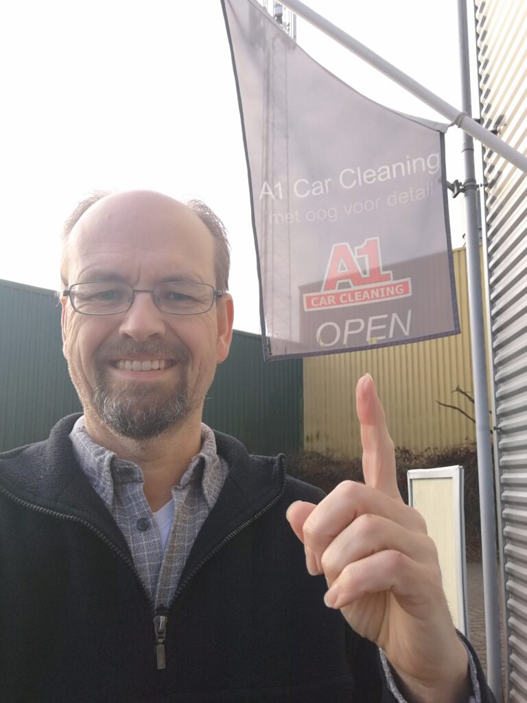 Harold wijzend naar vlag van A1 Car Cleaning